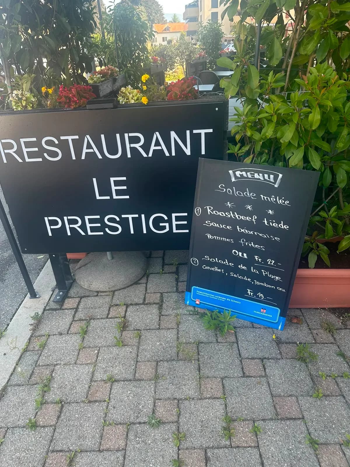 L'ardoise du menu du jour, écrite à la craie, posée devant l'entrée