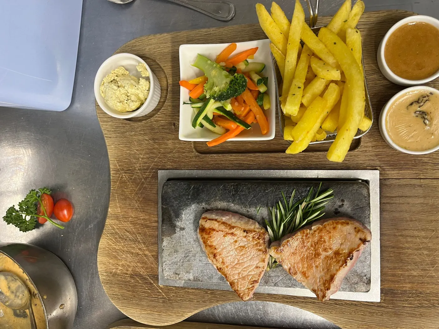 Une viande servie sur pierre chaude, légumes tournés et sauce à part